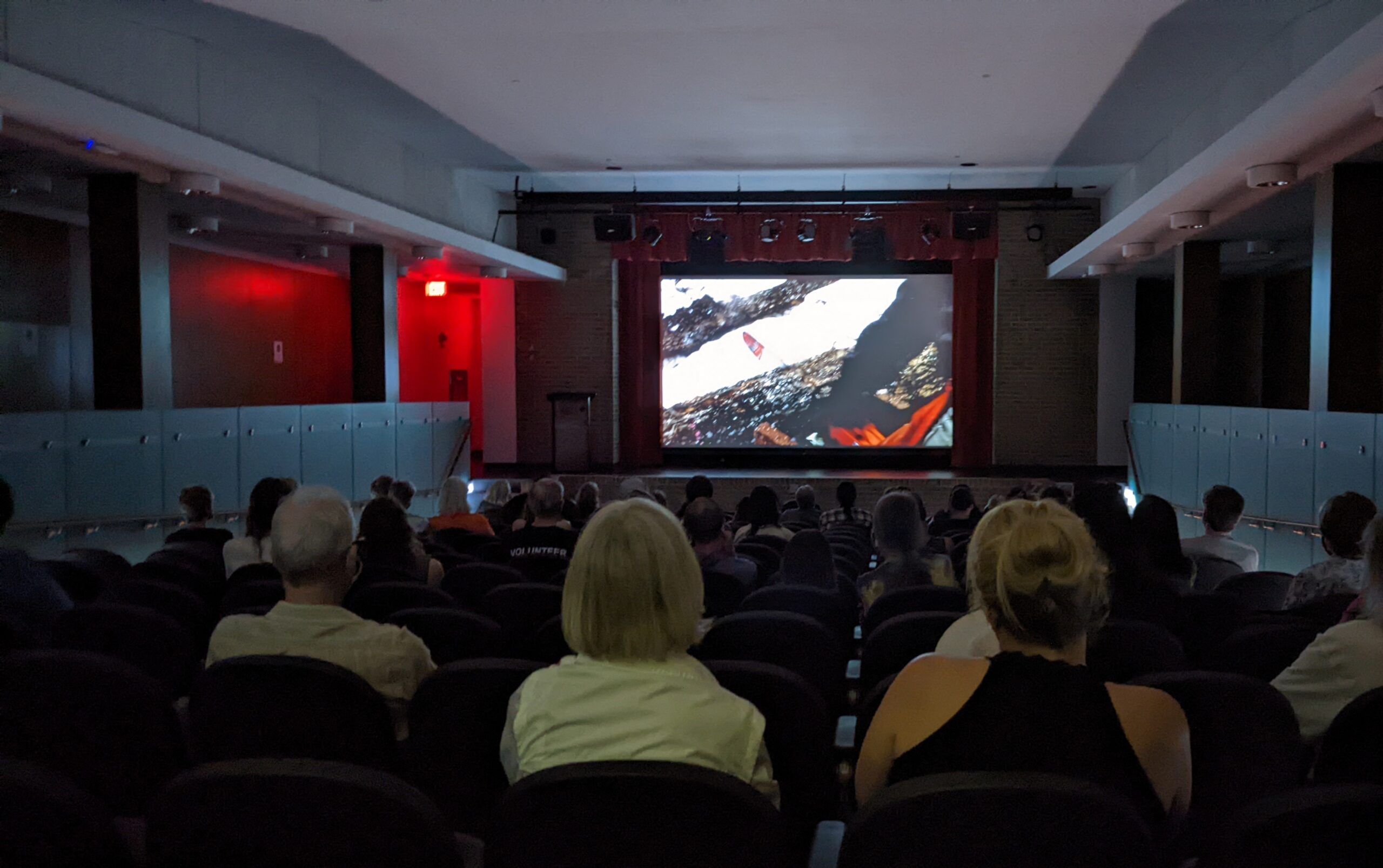 A theatre of people watching a movie